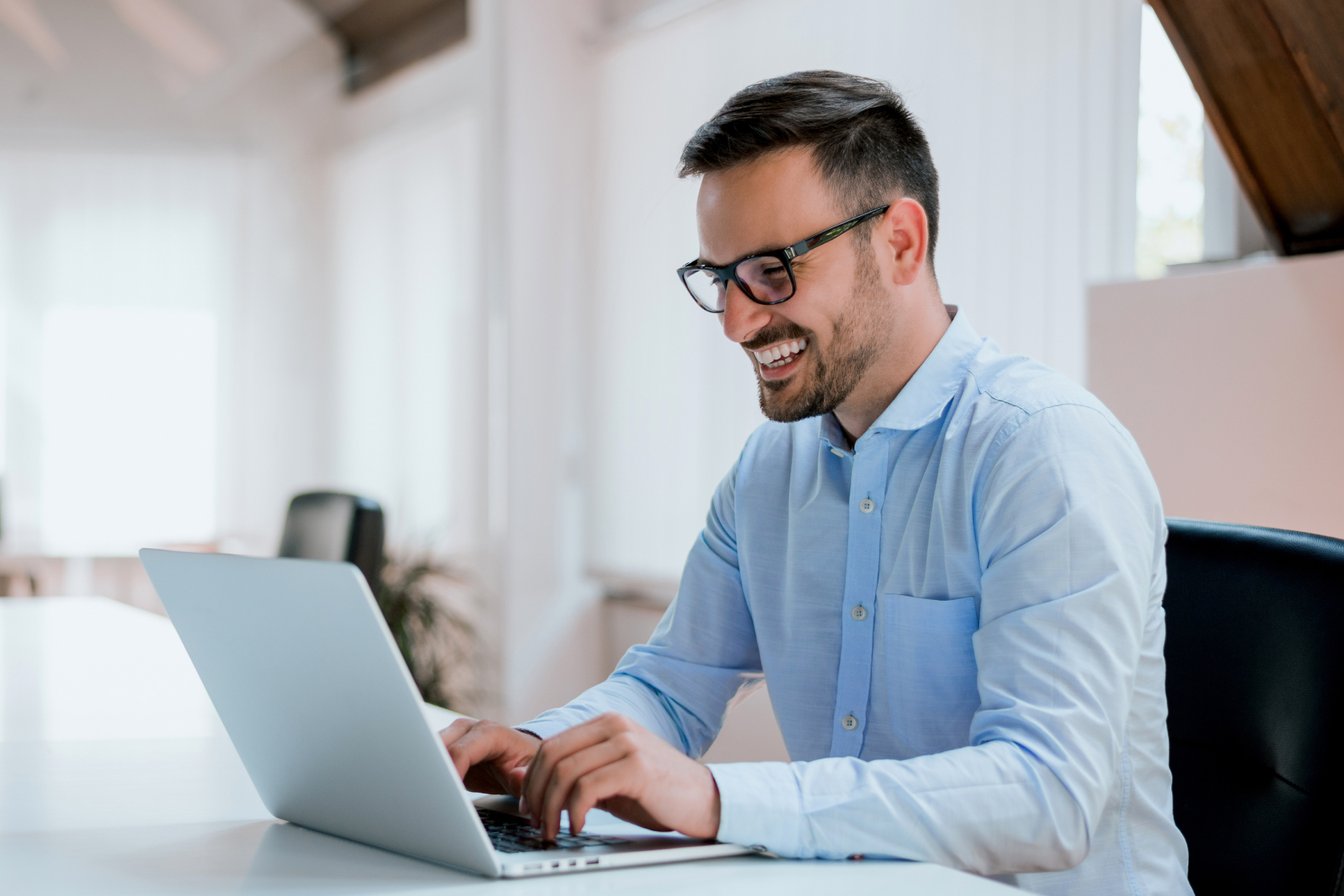 A smiling man seated in front of his laptop forms his sole proprietorship online.