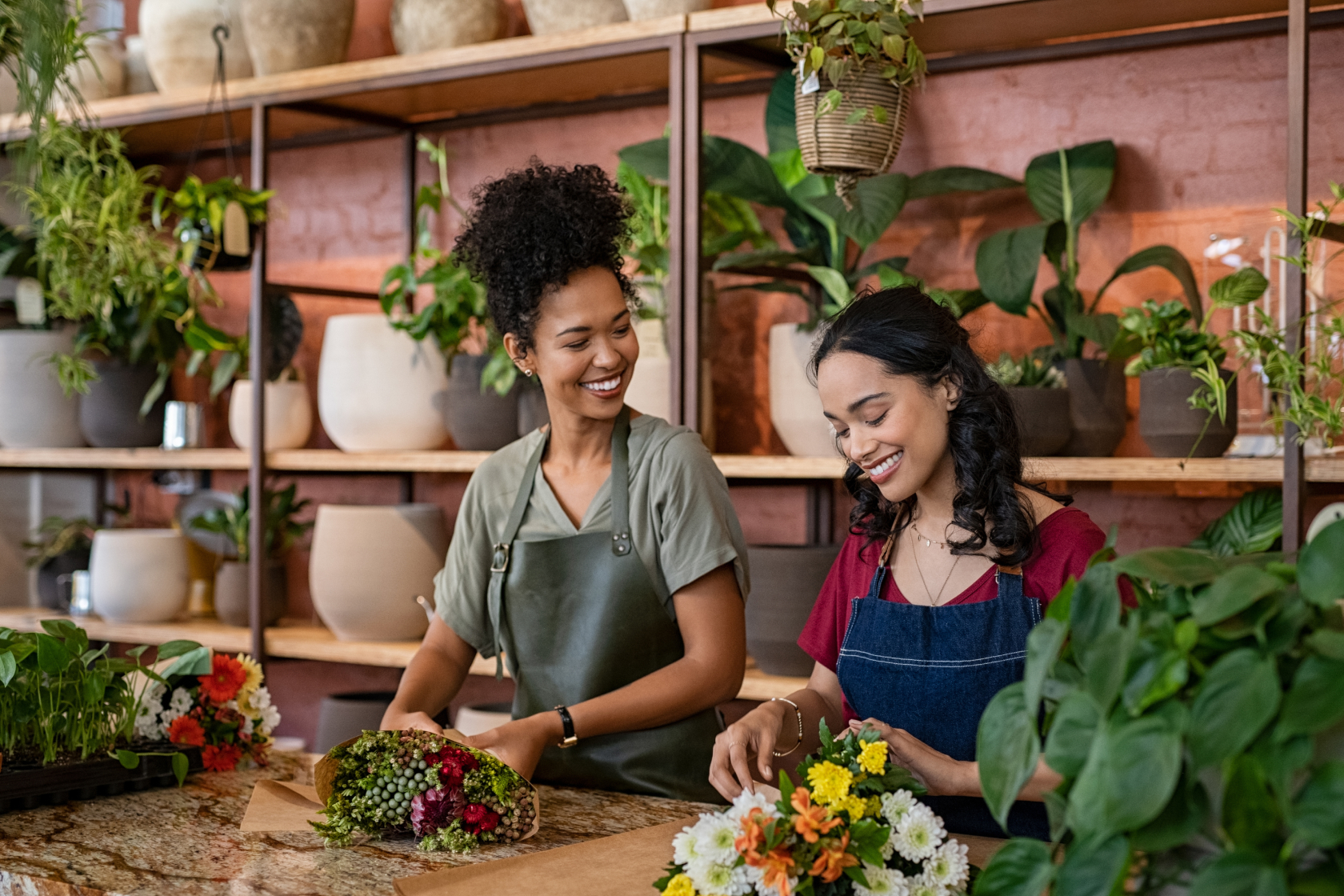 Owners of a plant shop work at the counter. Forming an LLC requires you to file articles of organization, sometimes called a certificate of organization, with the state. Requirements vary by state.