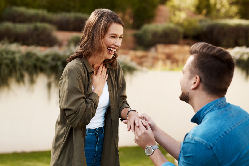 A woman looks joyful as her boyfriend gets on one knee and proposes. An Arizona prenuptial agreement must adhere to  state laws to be valid and enforceable.  