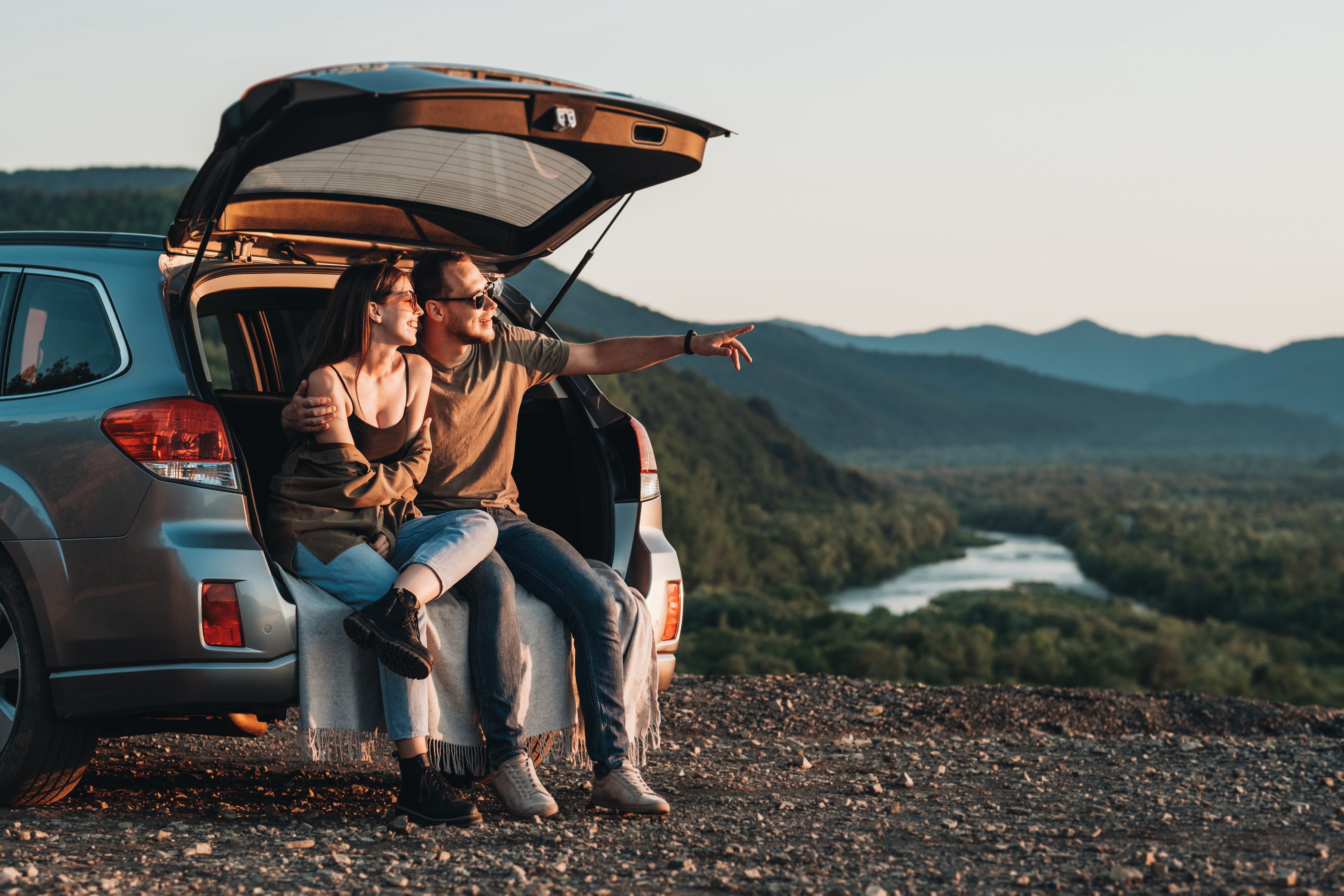 A newly married couple sit on the bumper of their van as they honeymoon. When a prenuptial agreement is done correctly, it’s beneficial to all prospective spouses.