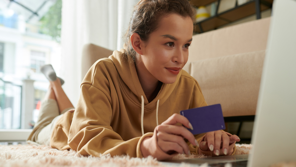 A woman holds her credit card while deciding whether to pay her taxes online.