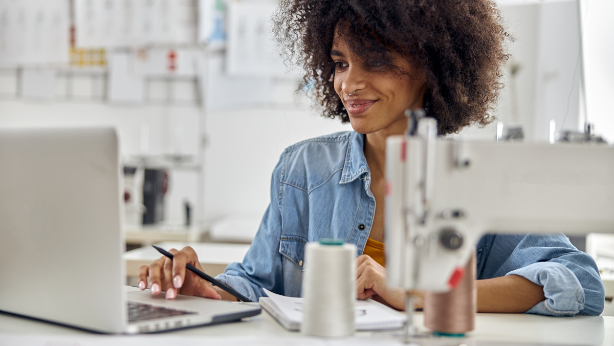 A woman looks at her laptop while taking notes. Determine if using sum of the years' digits may be right for your business.