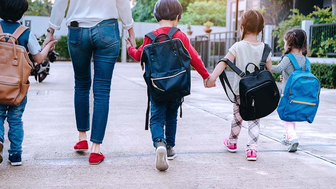 A mother and four children hold hands as they walk. Creating a Texas last will and testament ensures the proper consideration of inheritance rights for your spouse and children.