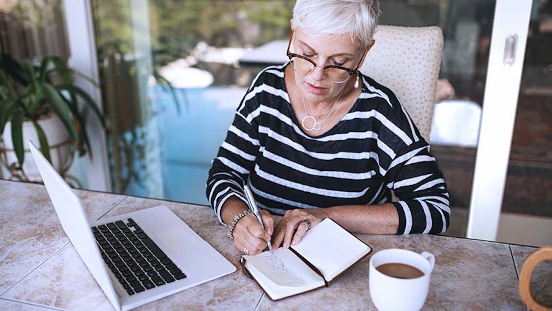 A woman sits at a kitchen counter and takes notes on living trusts. Assigning financial accounts to the trust constitutes another vital step in the process of transferring assets to a living trust. . 
