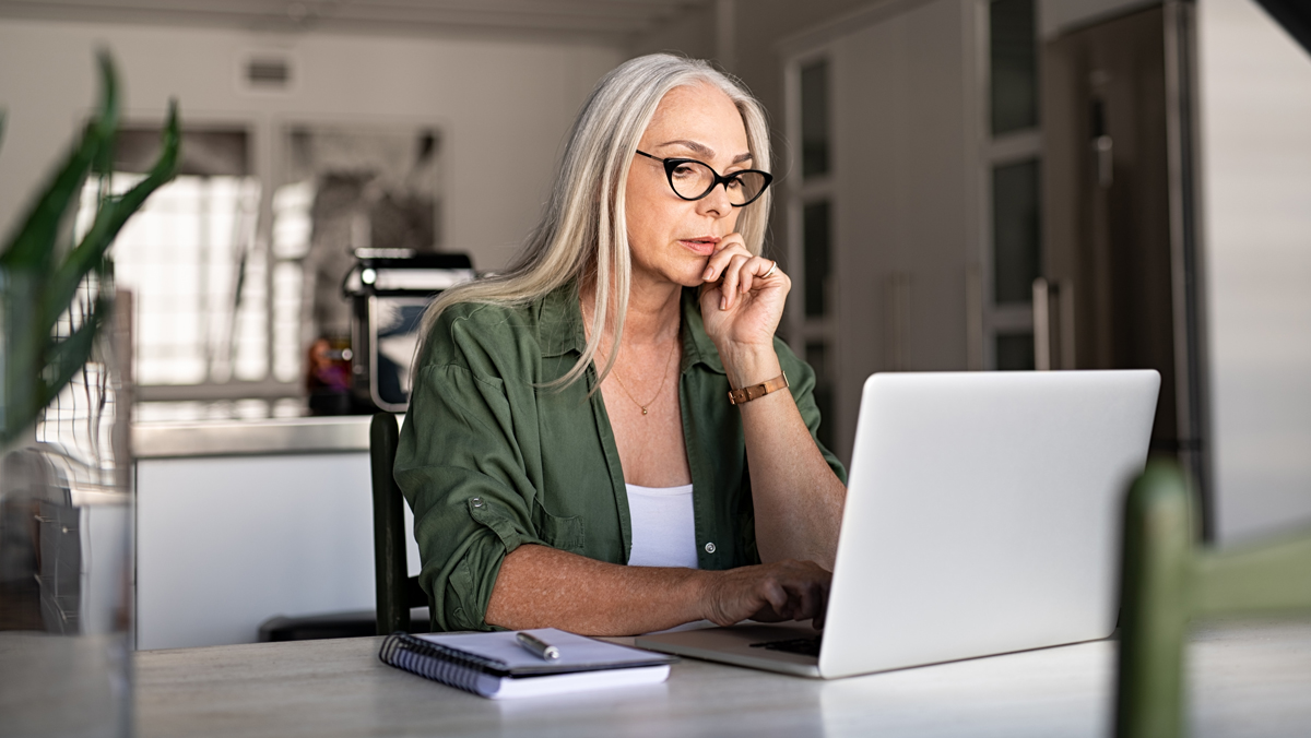 A woman studies the rule of wash sales on her laptop computer. Understanding how wash sale rules work will help you avoid losing the deduction when selling investments at a loss.