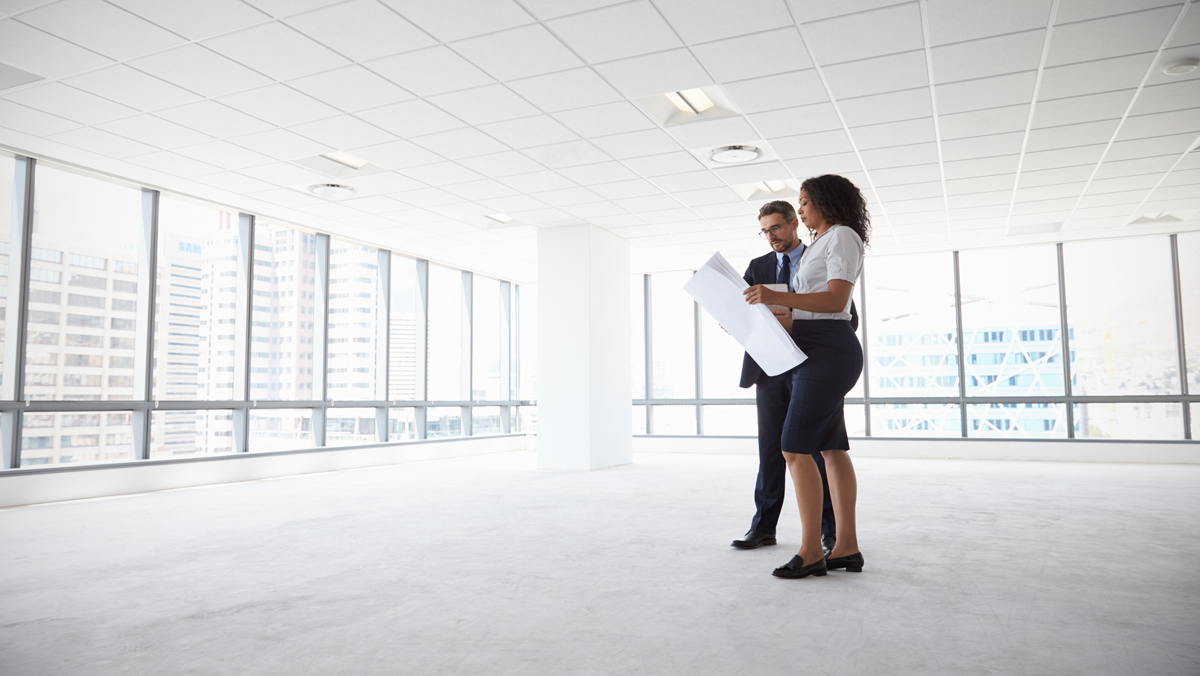 A man and woman visit a vacant space. You may be able to defer taxes on like-kind real estate with a 1031 form. 