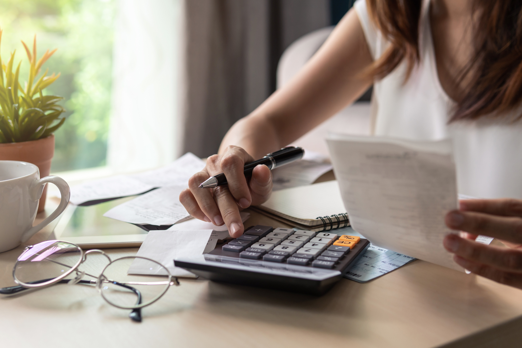A woman seated at a table holds receipts in one hand while working on calculator with the other hand. Learn what cash accounting is and why you might prefer it. An alternative is to use the accrual method of accounting.