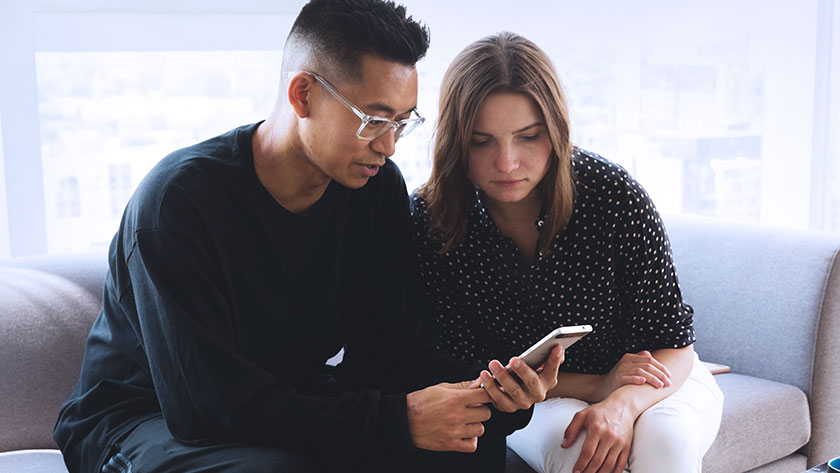 coworkers-looking-at-mobile-device