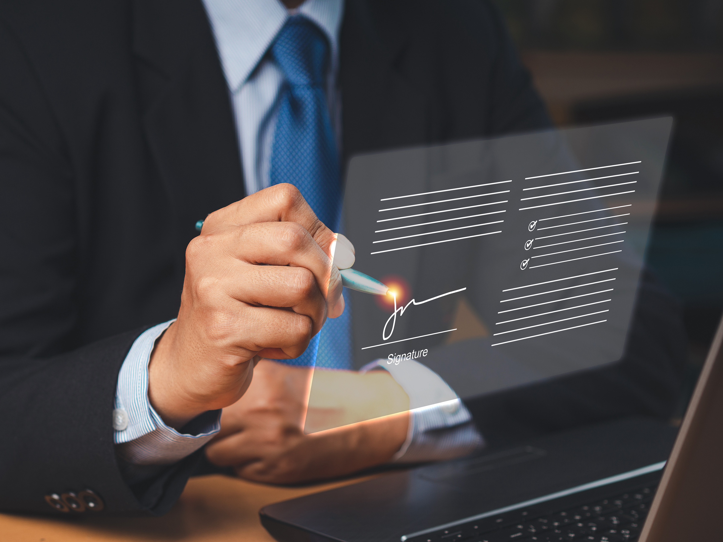 A person in a suit and tie signs a document digitally onscreen with eSignature by LegalZoom.