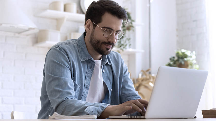 man in glasses working in laptop