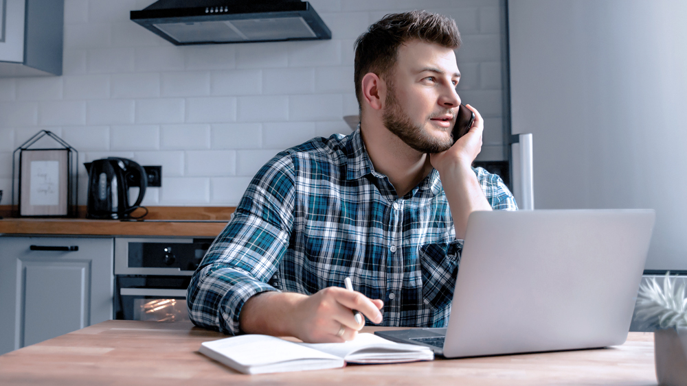 man looking out the window in home office