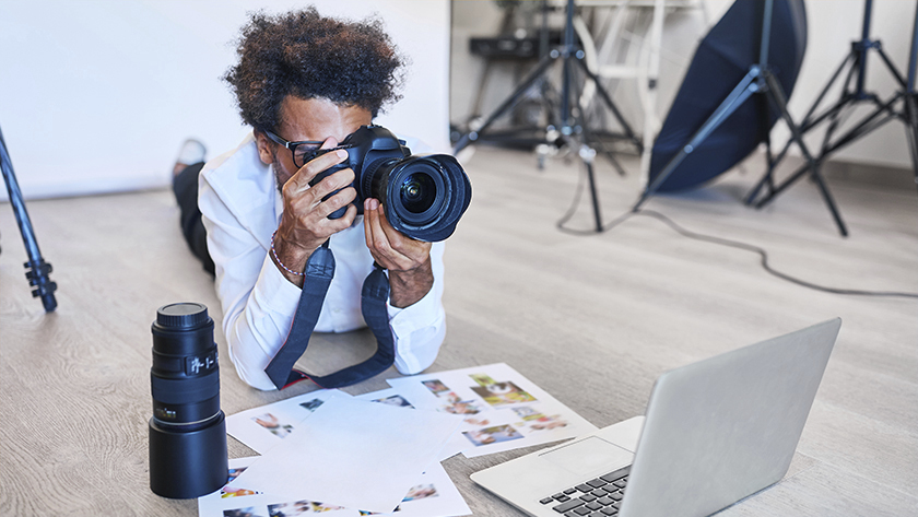 man taking pictures in front of a laptop