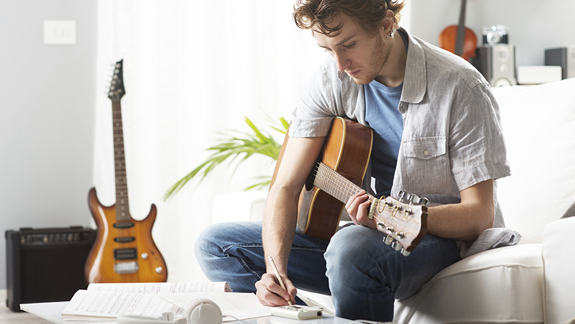 man writing music in home studio