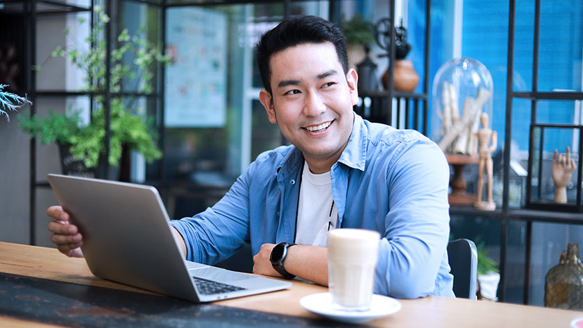 man-smiling-working-on-laptop-outside looking for registered agent