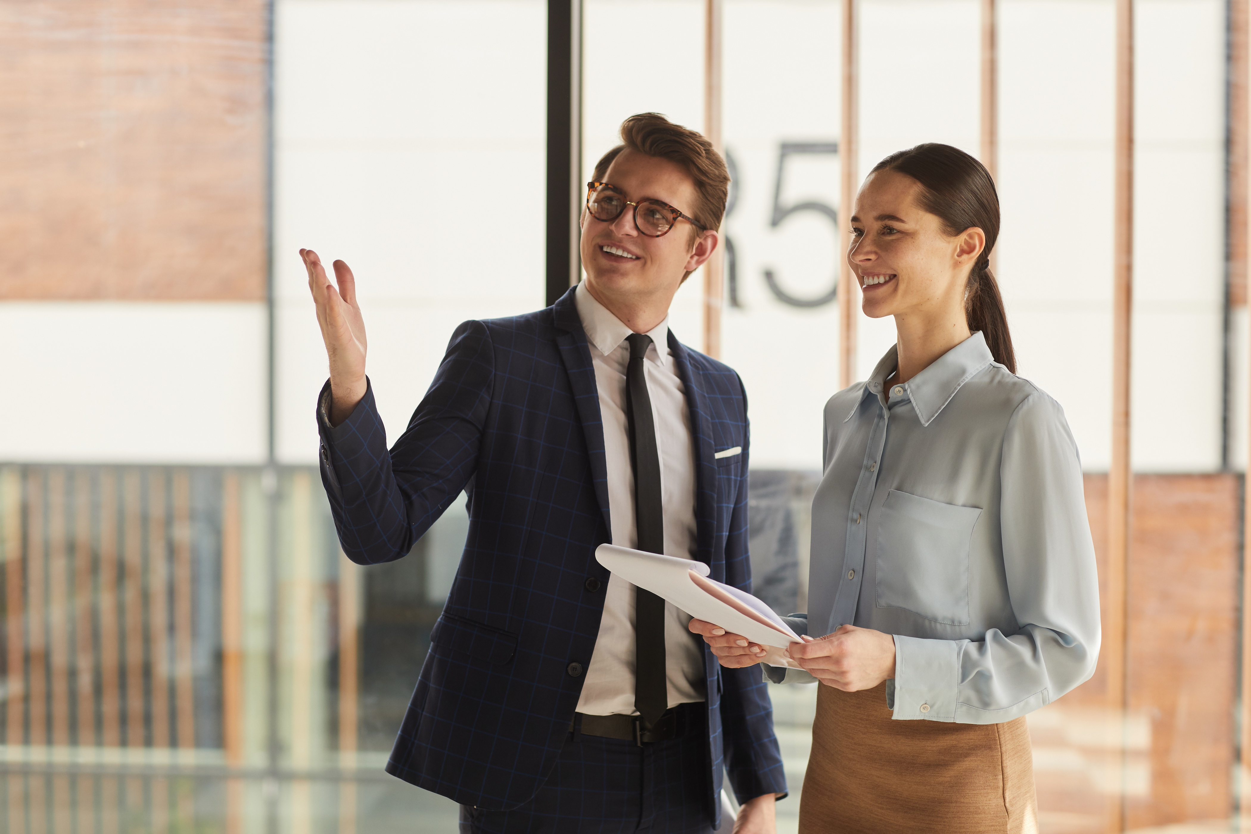 A real estate agent shows a prospective buyer an apartment buidling