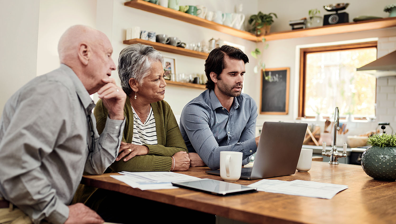 A family with elderly parents in a livingroom looking at documents together
