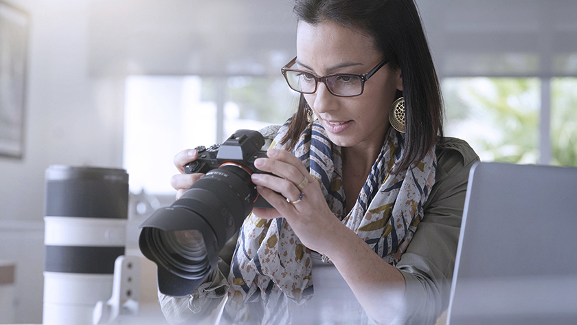 woman checking out pictures of DSLR camera