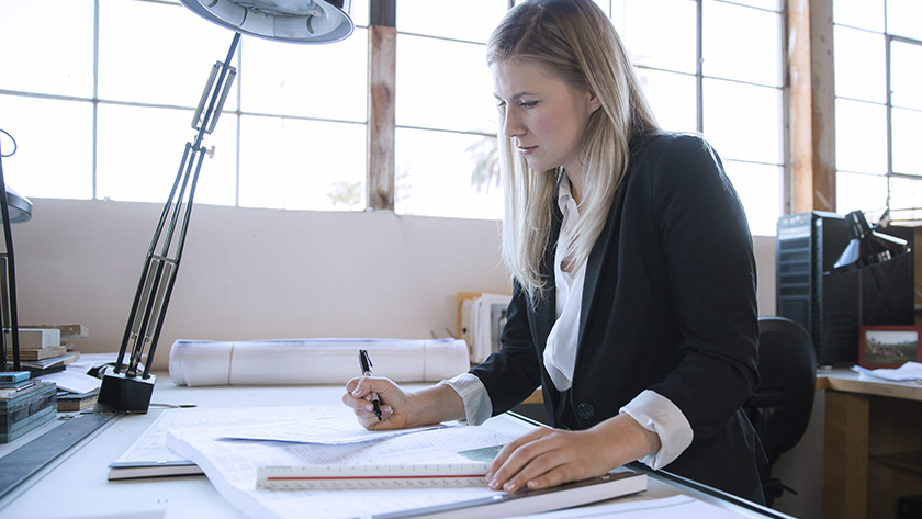 woman in black blazer going over paperwork 