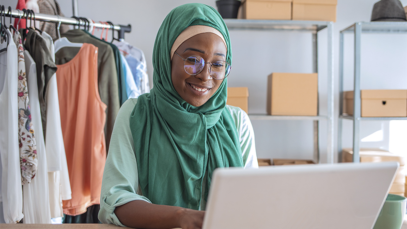 woman in green hijab working on laptop