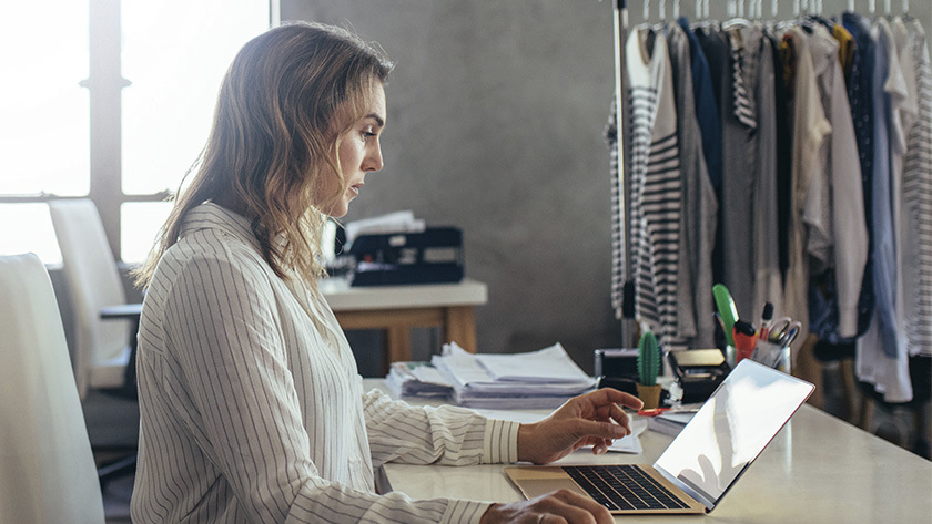 woman looking at laptop in her office