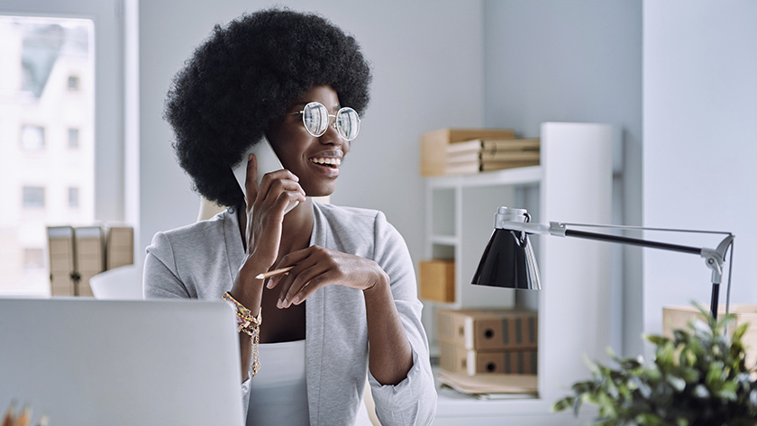 woman sitting at desk talking on the phone 