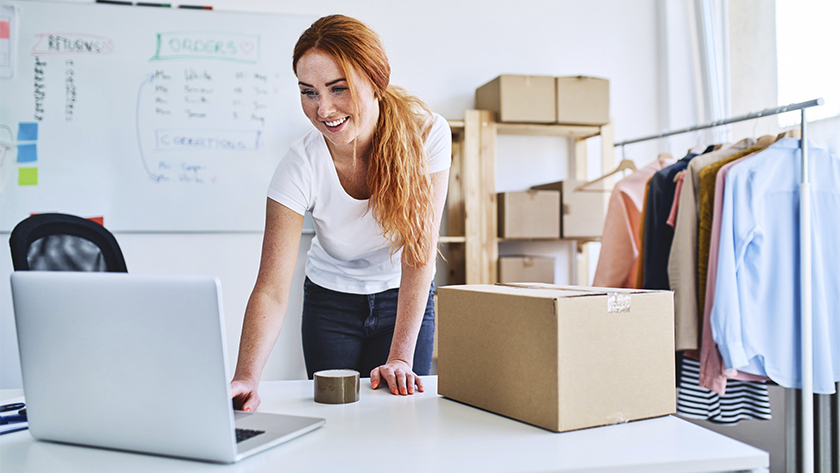 woman smiling looking at her laptop in her office