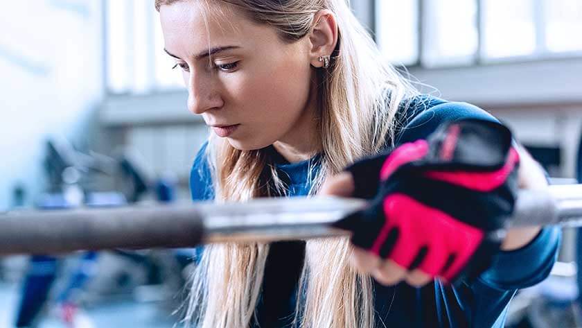 woman-in-gym-wearing-gloves-on-bar