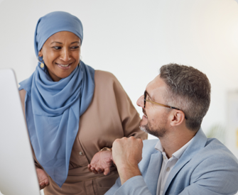 A woman and man business partners smiling that they are ready to file a Beneficial Ownership Information Report.