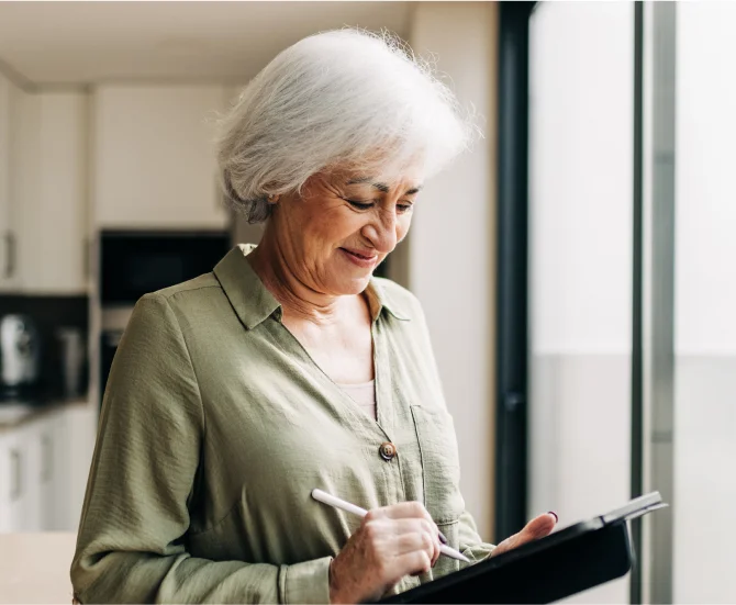 A woman signs documents using the service of an electronic signature provider that allows her to create electronic signatures like her handwritten signatures.